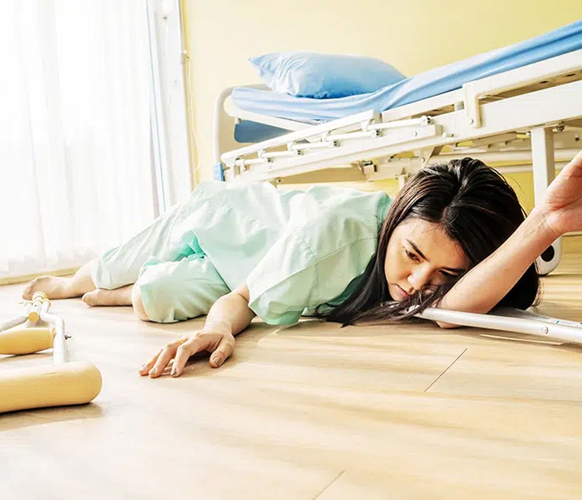 A patient who has fallen on the floor beside a hospital bed